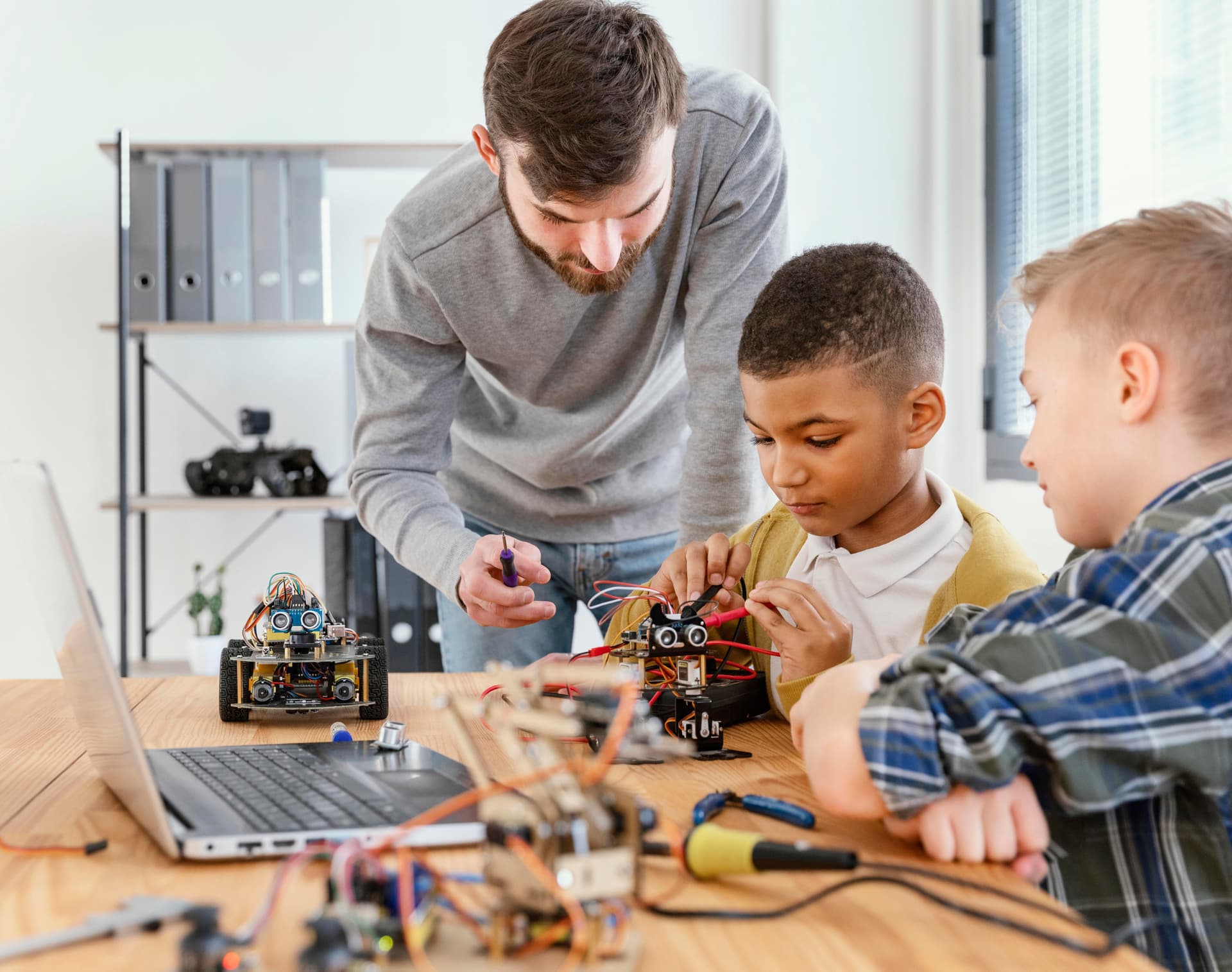 man and kids doing robotics